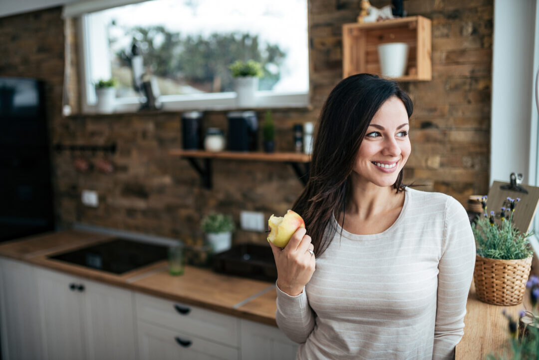 kvinna som äter äpple som mellanmål