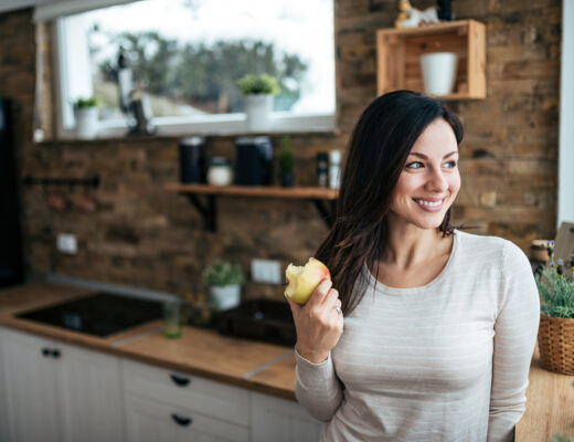 kvinna som äter äpple som mellanmål