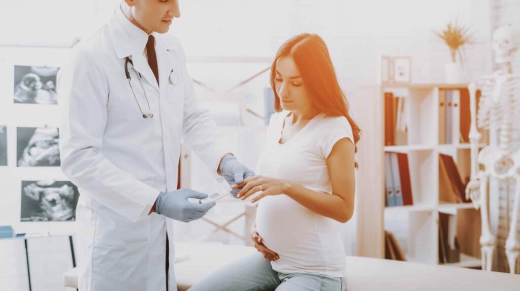 Läkaren kontrollerar gravid kvinna för graviditetsdiabetes.