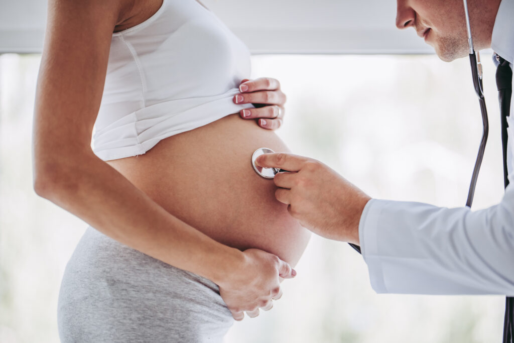 Gravid kvinna undersöks av läkare - att vänta barn som diabetiker